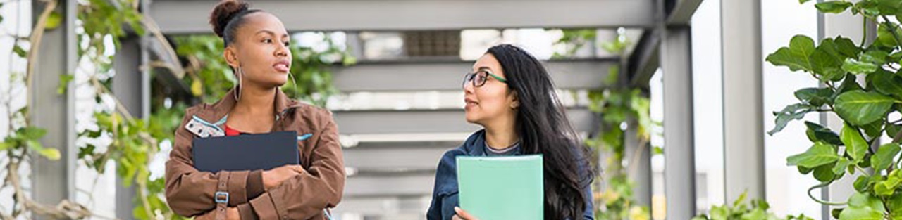 Two students walking in campus with books
